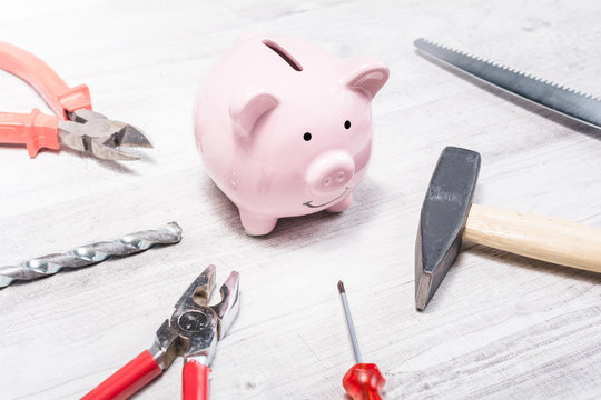 Pink Piggy Bank Surrounded By Tools Like Hammer, Pliers Or Saw - Open Piggybank Concept - Powered by Adobe