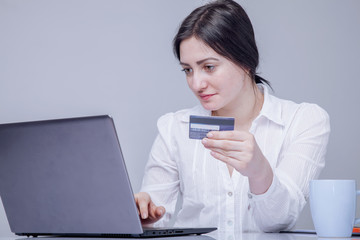 Business women working remotely цшер  credit card and using laptop computer. Business running through mobile systems. (Online shopping, world investments, marketing, ecommerce concept)