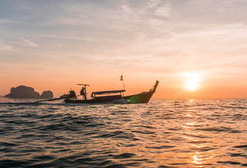Beautiful sunset with silhouette of Longtail boat on the horizon of the sea. Thailand