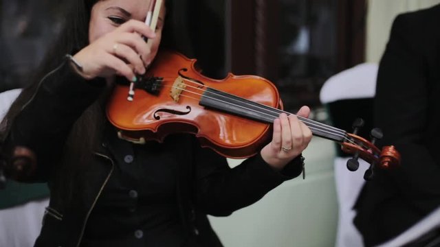 Musician playing violin outdoors. 
Violint play music for the wedding. Violin under the open sky. Wedding music concept.