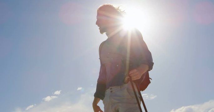 Man with hiking pole shielding his eyes 4k