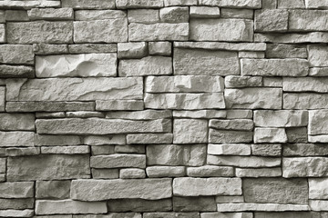Front view of monotone grey rough stone wall for background or banner 