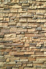 Vertical photo of brown and gray rough stone wall for background or banner 