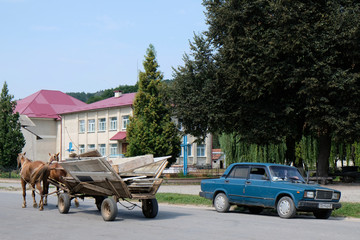 Ukraina - wóz konny i stary samochód na ulicy w mieście