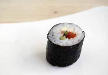 Sushi a dish of traditional Japanese cuisine cooked from rice, a salmon, vegetables and a nori. Close up. Sushi is on a dish.