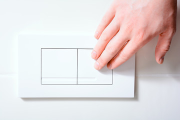 Male Hand Pressing Right Plate Of A Dual Flush Toilet For A Small Amount Of Water - Water Saving...