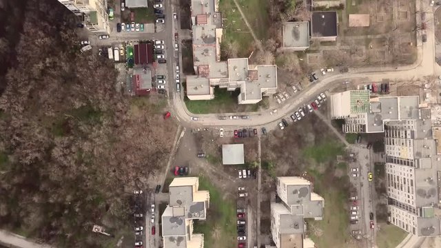 Flying over a concrete living apartment area in east Europa with many birds flying around the drone