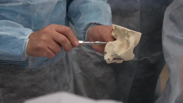 The dentist is screwing the implant