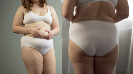 Fat lady looking at belly reflection, wants to lose excess weight, diabetes risk