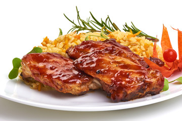 Delicious grilled pork ribs in BBQ sauce with pilaf, isolated on white background. Close-up