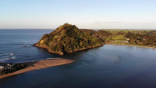 Drone shot over estuary with water going into sea. Pataua mount.