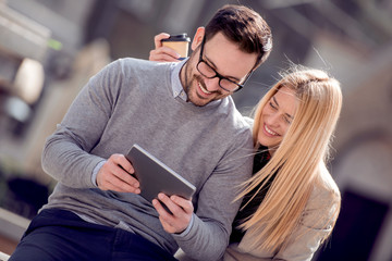 Cheerful couple using digital tablet