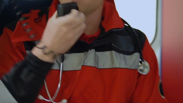 Man paramedic talking by radio, closing ambulance door to drive on call, 911