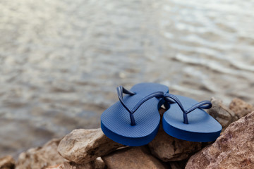 Closeup Of Blue Flip Flops On Rocky Beach At Summer Time