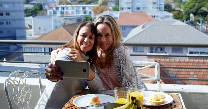 Lesbian couple taking selfie in balcony 4k