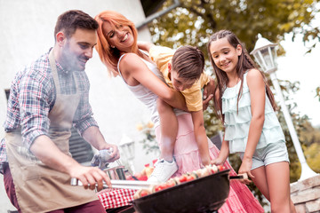 Young family make barbecue at their home