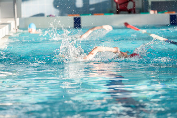 Group of children swimming crawl in pool, youth athletic school
