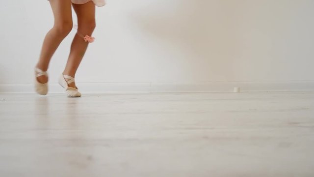 Little ballerina dancing on a white background. Attempt to dance on fingers