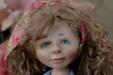 Face ceramic doll with blue eyes and freckles closeup.