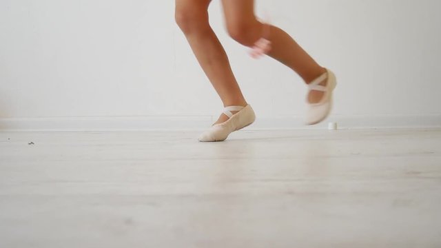Little ballerina dancing on a white background. Attempt to dance on fingers