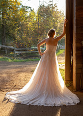 Back of bride leaning against barn