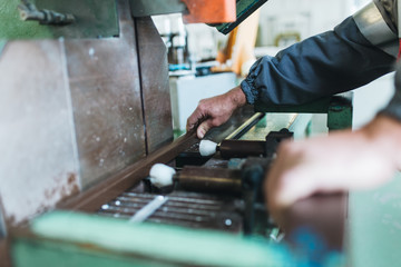 Manual worker cutting aluminum and PVC profiles. Manufacturing jobs. Selective focus. Factory for aluminum and PVC windows and doors production.