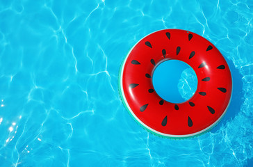 Obraz premium Inflatable ring floating in swimming pool on sunny day, top view with space for text