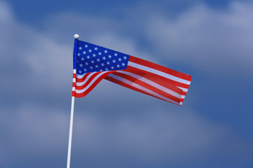 Small American flag against cloudy blue sky