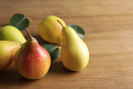 Ripe pears on wooden table. Space for text