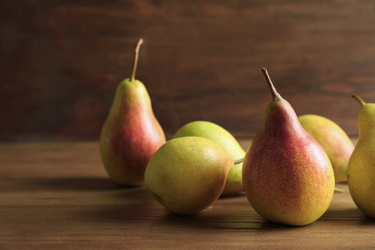 Ripe pears on wooden table. Space for text