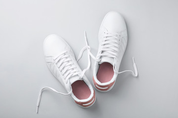 Pair of trendy sneakers on light background, flat lay