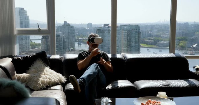 Man using virtual reality headset on sofa 4k