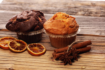 Chocolate muffin and nut muffin, homemade bakery on wooden background.
