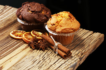 Chocolate muffin and nut muffin, homemade bakery on wooden background.