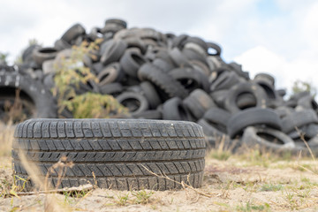 A stack of tires on an old garbage dump. Old worn out tires piled up.