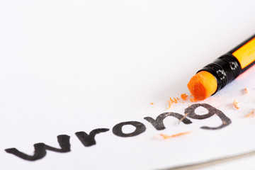Erase the word Wrong with a rubber concept of eliminating the error, mistake. closeup of a pencil...