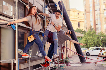 THREE YOUNG FRIENDS HAVING FUN ON CONSTRUCTION SITE