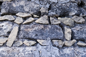 Stone wall, small stones forming square bricks.