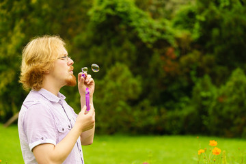 Man blowing soap bubbles outdoor