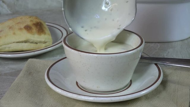 Serving clam chowder with a soup ladle
