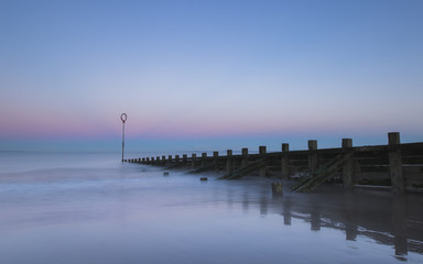 Fototapeta na wymiar Old wooden Groyne on Portobello beach at sunset