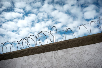 Barbed wire fence with cloudy sky
