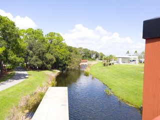Walking path in a park under a bright sunny blue sky with white puffy clouds