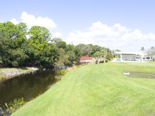 Walking path in a park under a bright sunny blue sky with white puffy clouds