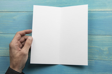 Obraz premium Mens hand holding white booklet