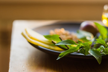 Fresh ingredients for preparing Italian pesto sauce - lemon basil sprigs, peeled seeds of cedar nuts, large garlic clove, Greek olive oil, Parmesan cheese
