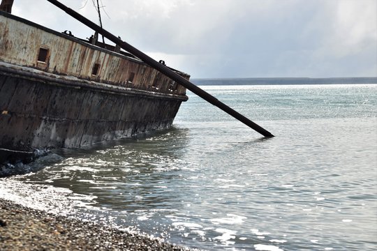 Vieja barca encallada en la playa con la marea alta