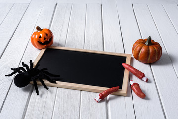 halloween background with Pumpkins, black spider and chalkboard on wooden floor background