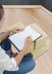 courier making notes in delivery receipt among parcels on boxes