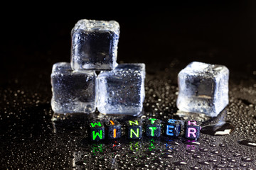 ice cubes reflection and Winter on black table background.